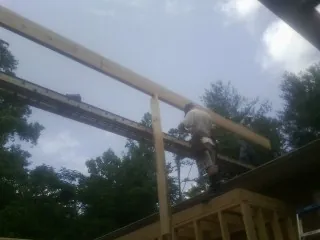 Carpenter setting a ridge beam over a new addition frame — Ice Dam Removal by Roofing Brothers in Lone Tree