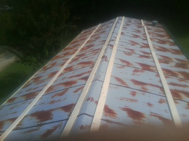Rusted metal roof panels with new wood purlins before replacement — Storm Damage Roof Repair in Lone Tree by Roofing Brothers